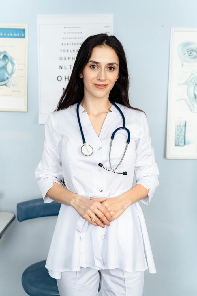 Portrait of a smiling female doctor with a stethoscope in a bright, clinical environment.